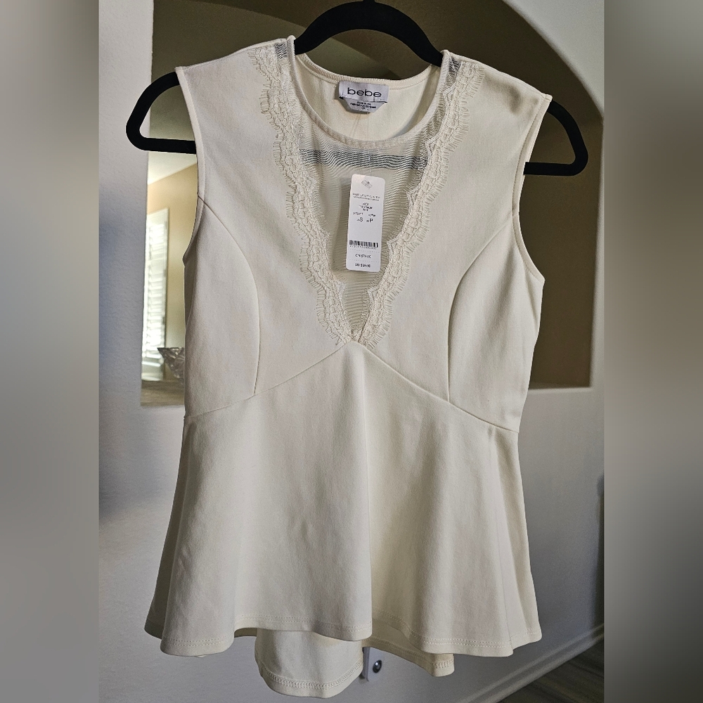 New bebe peplum off white blouse size S with with see-through V lace neckline.